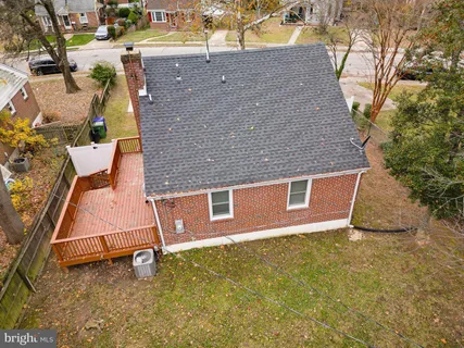 an aerial view of a house with a yard and large tree