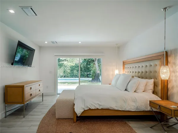 a bedroom with a bed and a flat screen tv