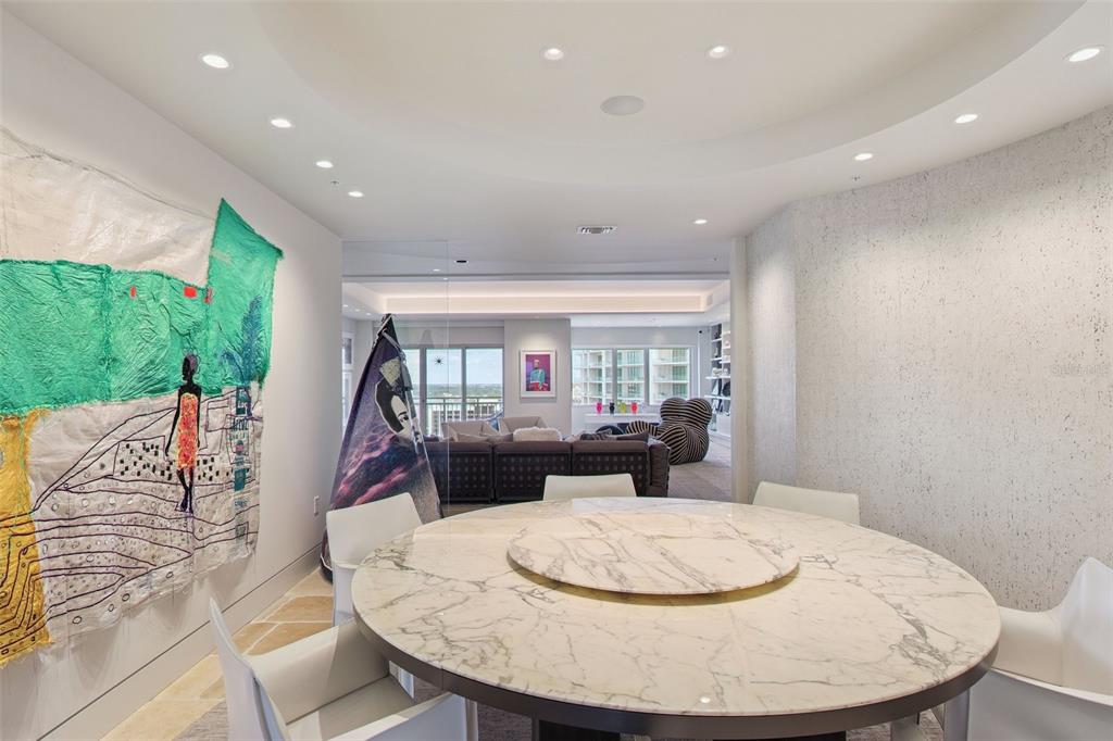 1111 Ritz Carlton Drive, Unit 1704 Sarasota, FL 34236 - Photo 19 of 53 a living room with furniture and a dining table with garden view