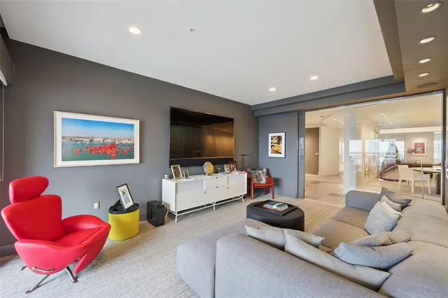 a living room with furniture a large window and a chandelier