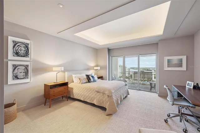 a bedroom with a bed a couch and a flat screen tv