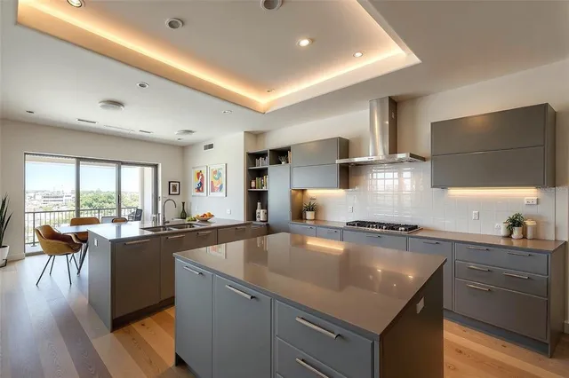 a kitchen with stainless steel appliances granite countertop a sink stove and cabinets