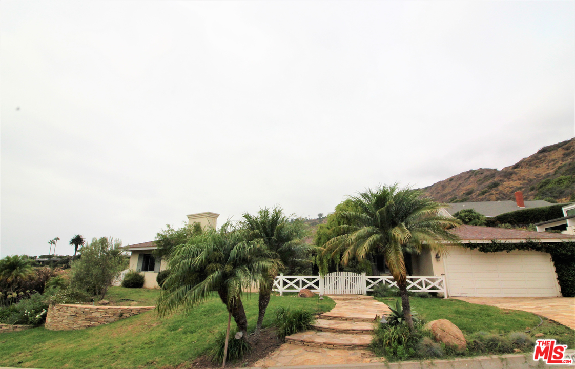 20219 Inland Lane Malibu, CA 90265 - Photo 2 of 28 a view of a house with a yard and potted plants