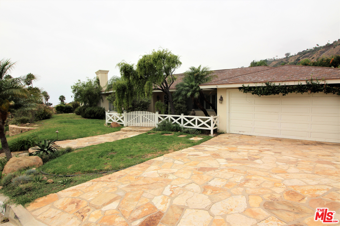 20219 Inland Lane Malibu, CA 90265 - Photo 12 of 28 a front view of a house with a yard and garage