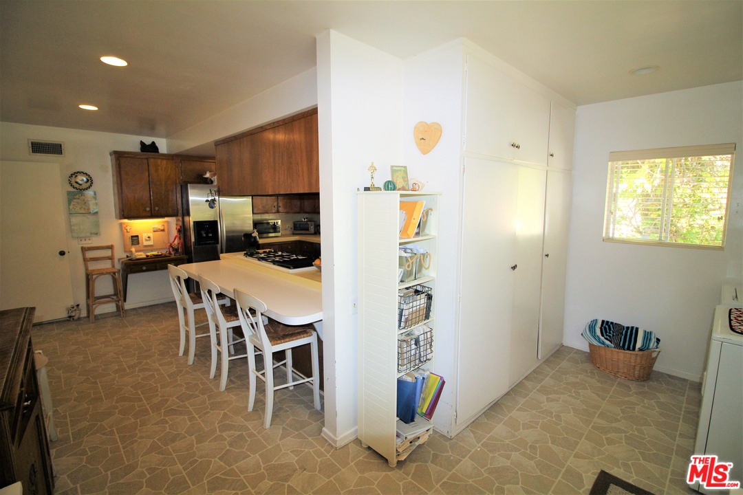 20219 Inland Lane Malibu, CA 90265 - Photo 25 of 28 a kitchen with stainless steel appliances kitchen island granite countertop refrigerator and cabinets