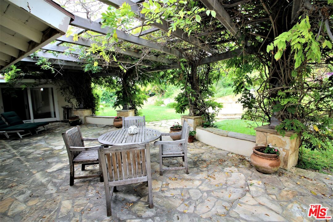 20219 Inland Lane Malibu, CA 90265 - Photo 9 of 28 a view of a patio with table and chairs and potted plants