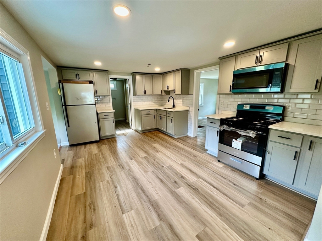 12 English Road Holbrook, MA 02343 - Photo 4 of 12 a kitchen with sink a refrigerator and a stove top oven