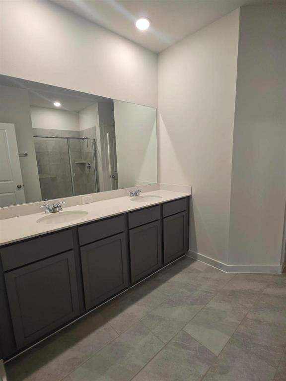508 Weller Road McKinney, TX 75069 - Photo 11 of 16 Contemporary bathroom featuring a spacious dual vanity with dark gray cabinetry, light-toned countertops, and two undermount sinks