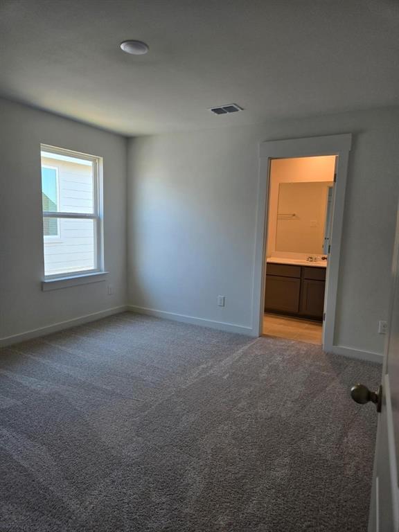 508 Weller Road McKinney, TX 75069 - Photo 14 of 16 Carpeted room featuring a white-trimmed window, recessed ceiling light, and direct access to a bathroom with a vanity and mirror