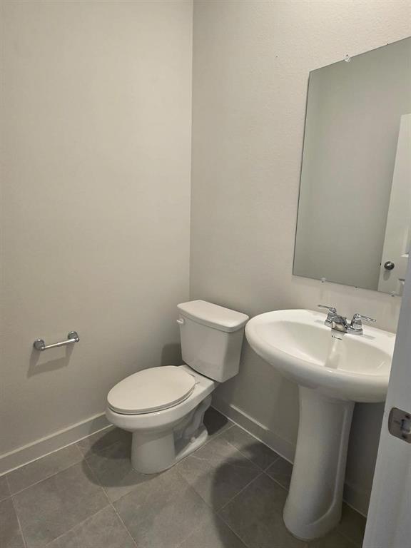 508 Weller Road McKinney, TX 75069 - Photo 7 of 16 Powder room featuring a white pedestal sink with chrome faucet, white toilet, and wall-mounted mirror