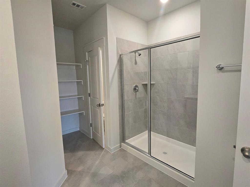 508 Weller Road McKinney, TX 75069 - Photo 9 of 16 Contemporary shower with a glass enclosure, tiled walls, and a recessed niche