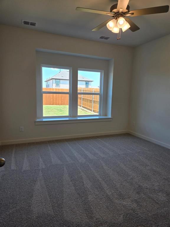 508 Weller Road McKinney, TX 75069 - Photo 10 of 16 Light-filled interior space featuring neutral tone wall paint, a ceiling fan with integrated lighting, and plush carpet flooring