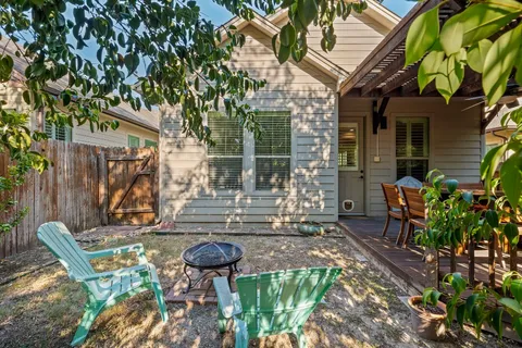 a view of a chair and table in backyard of the house