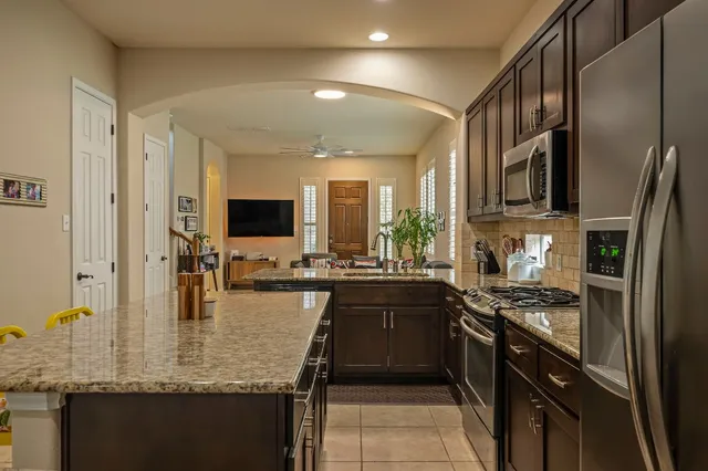 a kitchen with stainless steel appliances granite countertop a sink stove and refrigerator