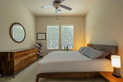 a bedroom with a bed and a lamp on dresser