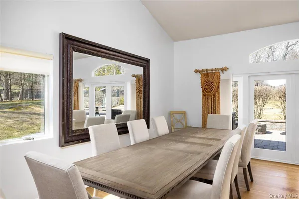 a dining room with stainless steel appliances granite countertop a dining table chairs a refrigerator and a granite counter tops