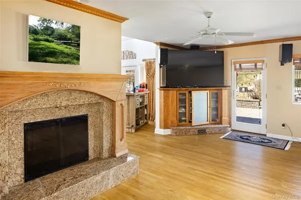 a living room with furniture large window and wooden floor