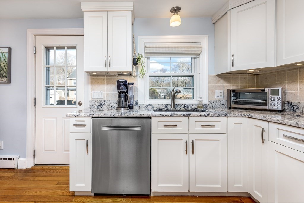 32 Norman Road Hamilton, MA 01982 - Photo 7 of 39 a kitchen with granite countertop white cabinets and white appliances