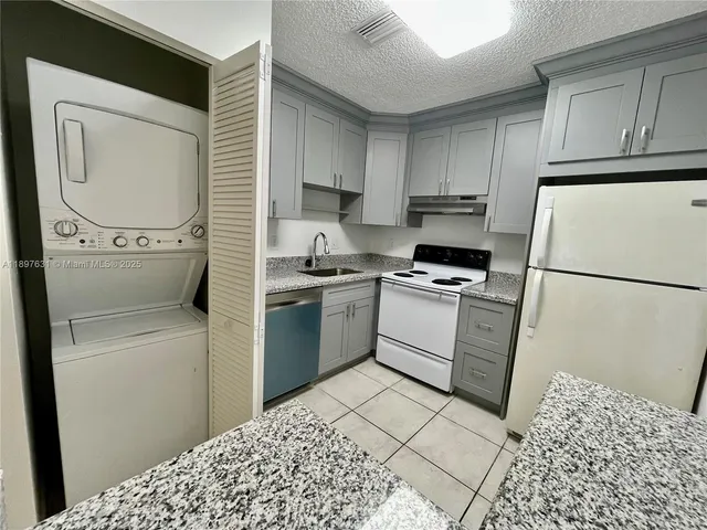 a kitchen with a refrigerator sink and cabinets
