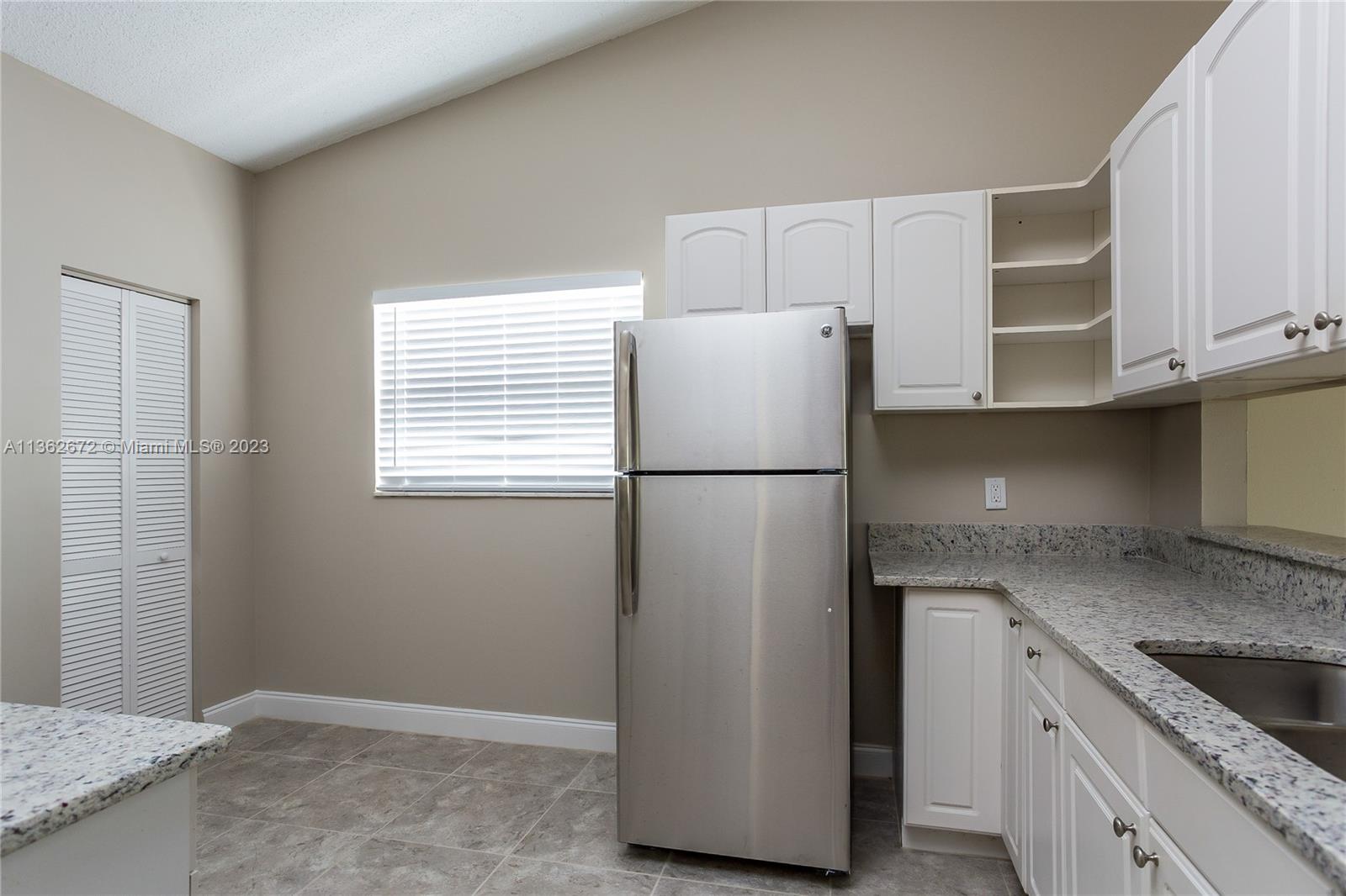 134 Timberline Drive Jupiter, FL 33458 - Photo 6 of 15 a kitchen with cabinets and stainless steel appliances