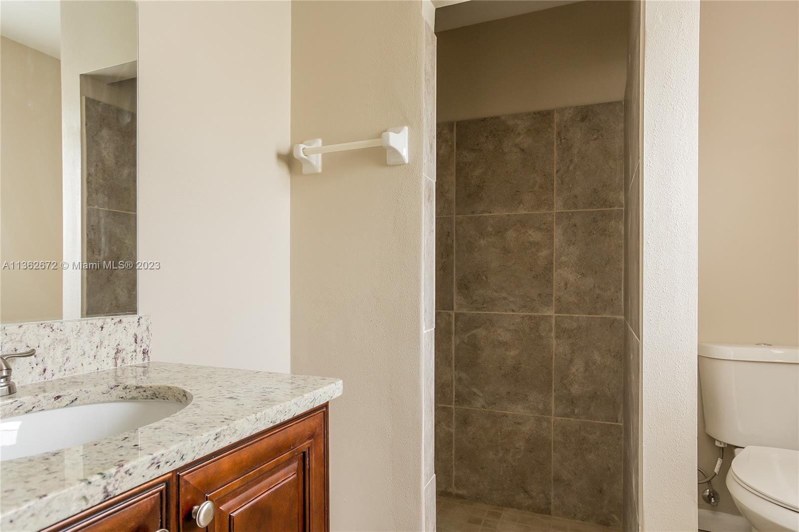 134 Timberline Drive Jupiter, FL 33458 - Photo 9 of 15 a bathroom with a granite countertop sink a toilet and shower