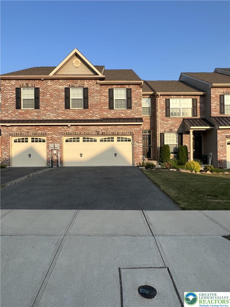 5380 Jutland Road Allentown, PA 18104 - Photo 1 of 27 Brick facade townhome with dual garage doors and a well-kept lawn, ready for new residents.