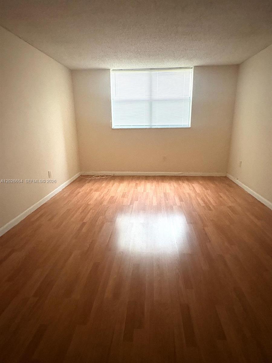 4174 Inverrary Drive, Unit 903 Lauderhill, FL 33319 - Photo 29 of 36 an empty room with wooden floor and windows