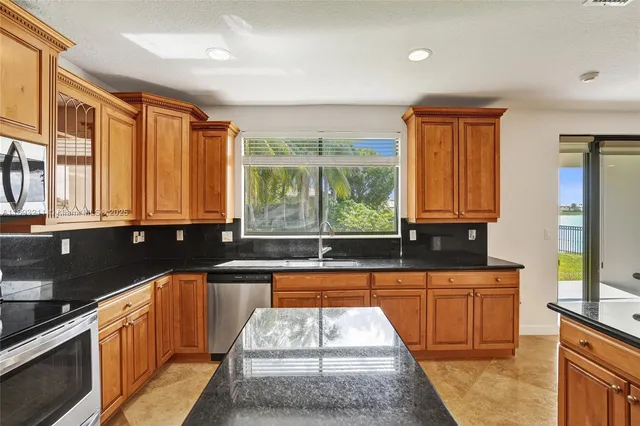 a kitchen that has a sink a refrigerator and cabinets