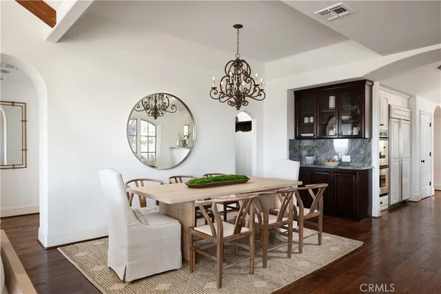 a dining room with furniture a chandelier and wooden floor