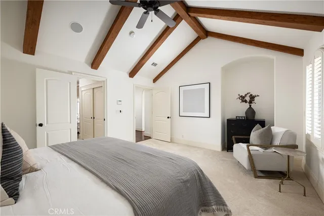 a bedroom with a bed a mirror and a chandelier