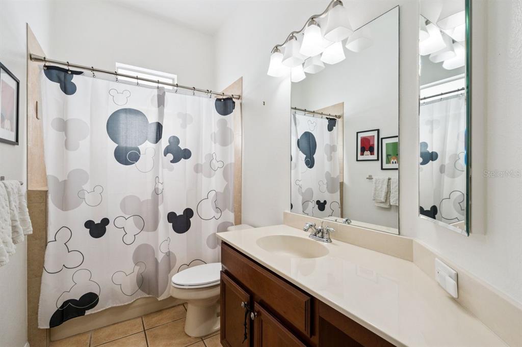 8484 Dover View Lane Orlando, FL 32829 - Photo 23 of 41 a bathroom with a granite countertop sink a toilet and shower