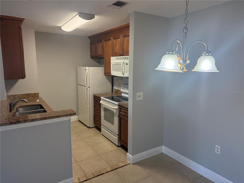 8932 Manor Loop, Unit 205 Lakewood Ranch, FL 34202 - Photo 13 of 15 a kitchen that has a sink cabinets and stainless steel appliances