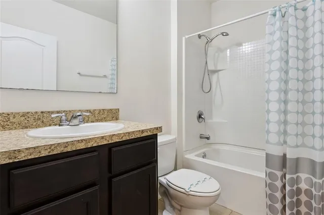 a bathroom with a granite countertop sink a toilet and shower