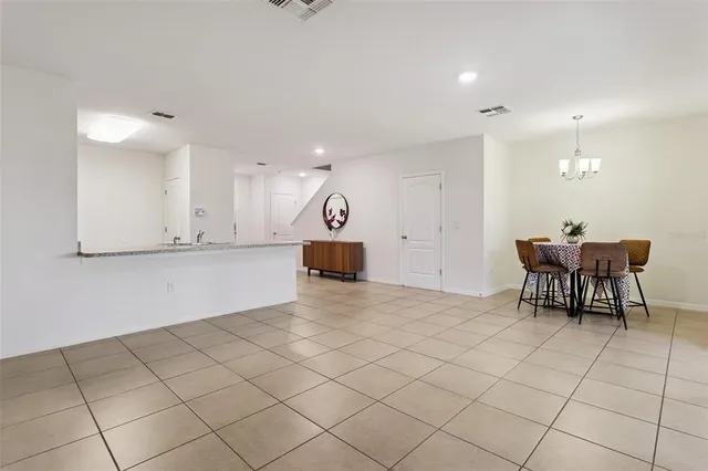 a view of a kitchen with kitchen island white cabinets and stainless steel appliances