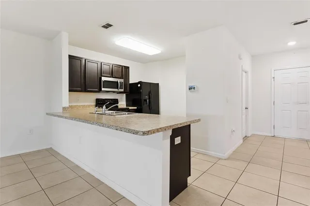a kitchen with granite countertop a sink and a stove top oven
