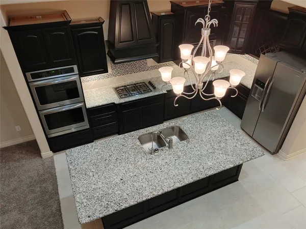 a bathroom with a granite countertop sink a mirror and shower