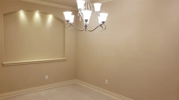 an empty room with a chandeliers fan