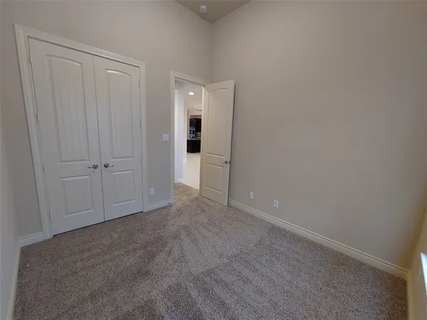a view of an empty room with a chandelier fan