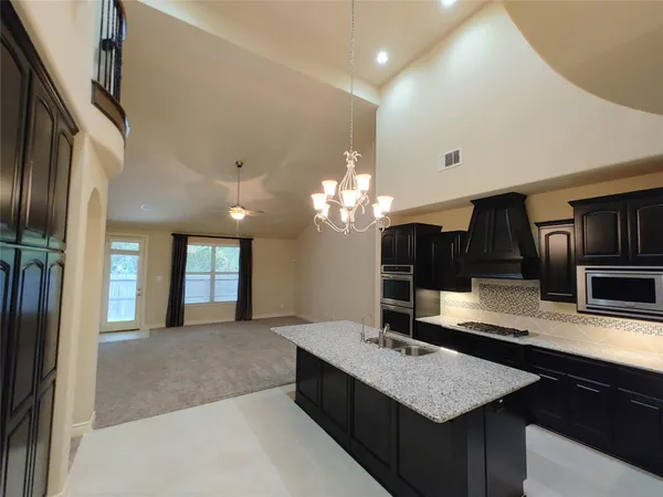 a large kitchen with kitchen island granite countertop a sink counter space and stainless steel appliances