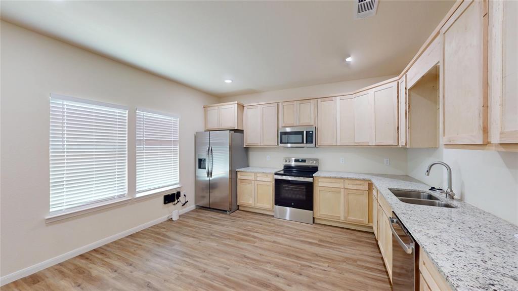 18636 Doubletree Drive Justin, TX 76247 - Photo 4 of 35 a kitchen with stainless steel appliances granite countertop a sink stove refrigerator and cabinets