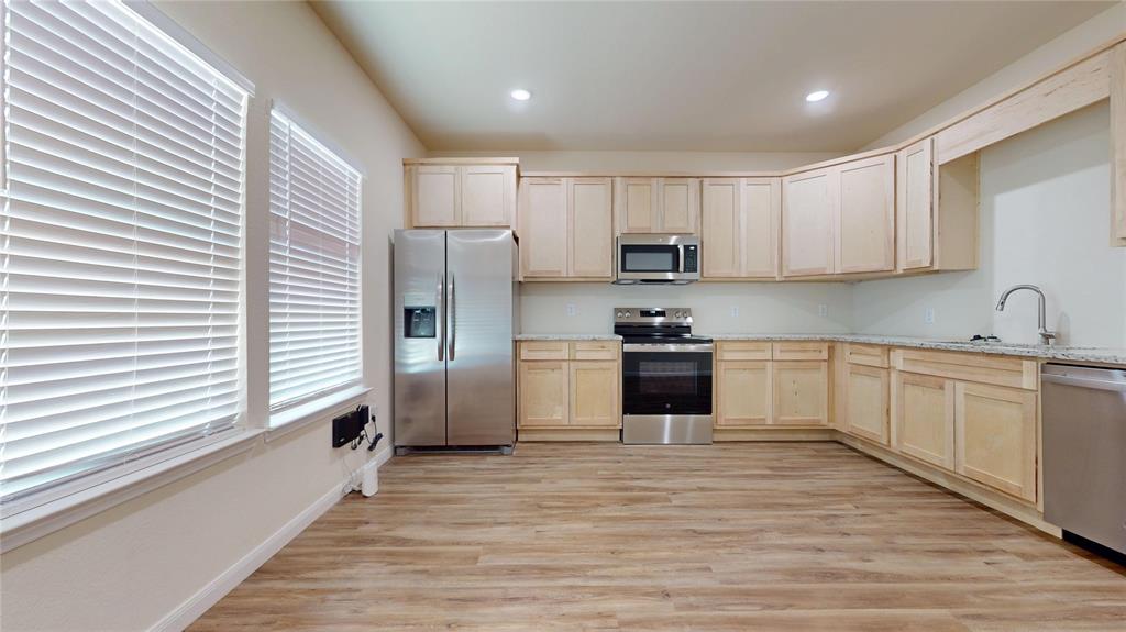 18636 Doubletree Drive Justin, TX 76247 - Photo 5 of 35 a kitchen with stainless steel appliances granite countertop a refrigerator and a stove top oven