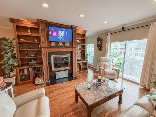 a view of an empty room with a fireplace and wooden floor