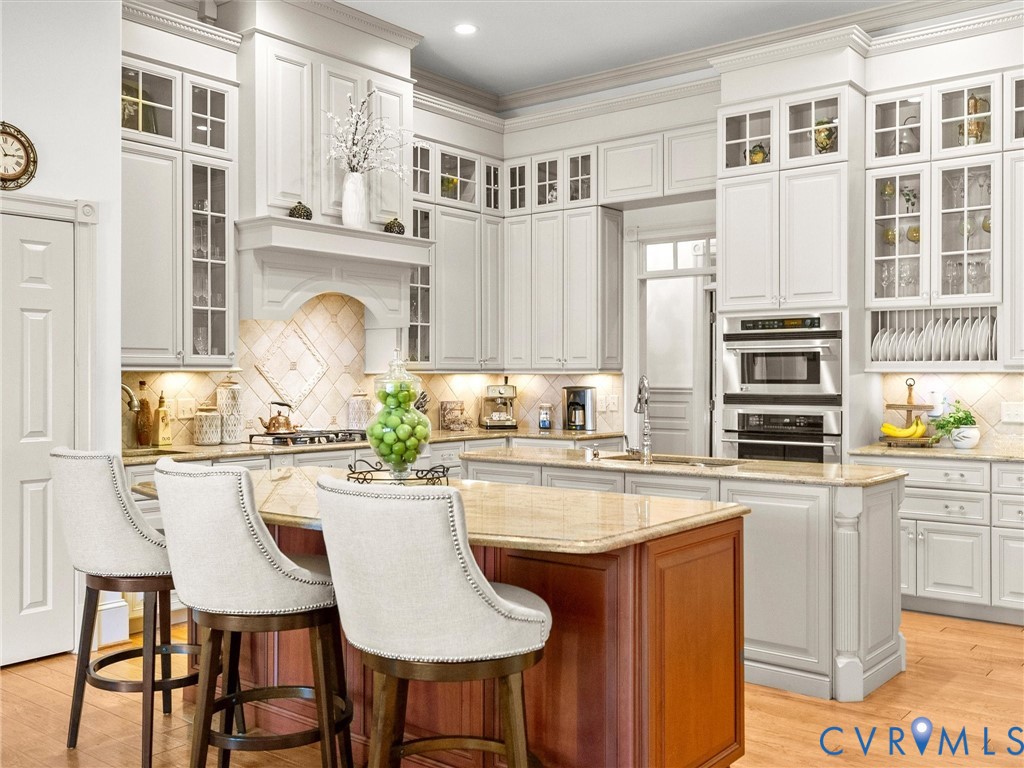 24200 Pear Orchard Road Moseley, VA 23120 - Photo 28 of 66 a kitchen with stainless steel appliances granite countertop a stove a sink a oven a dining table and chairs with wooden floor