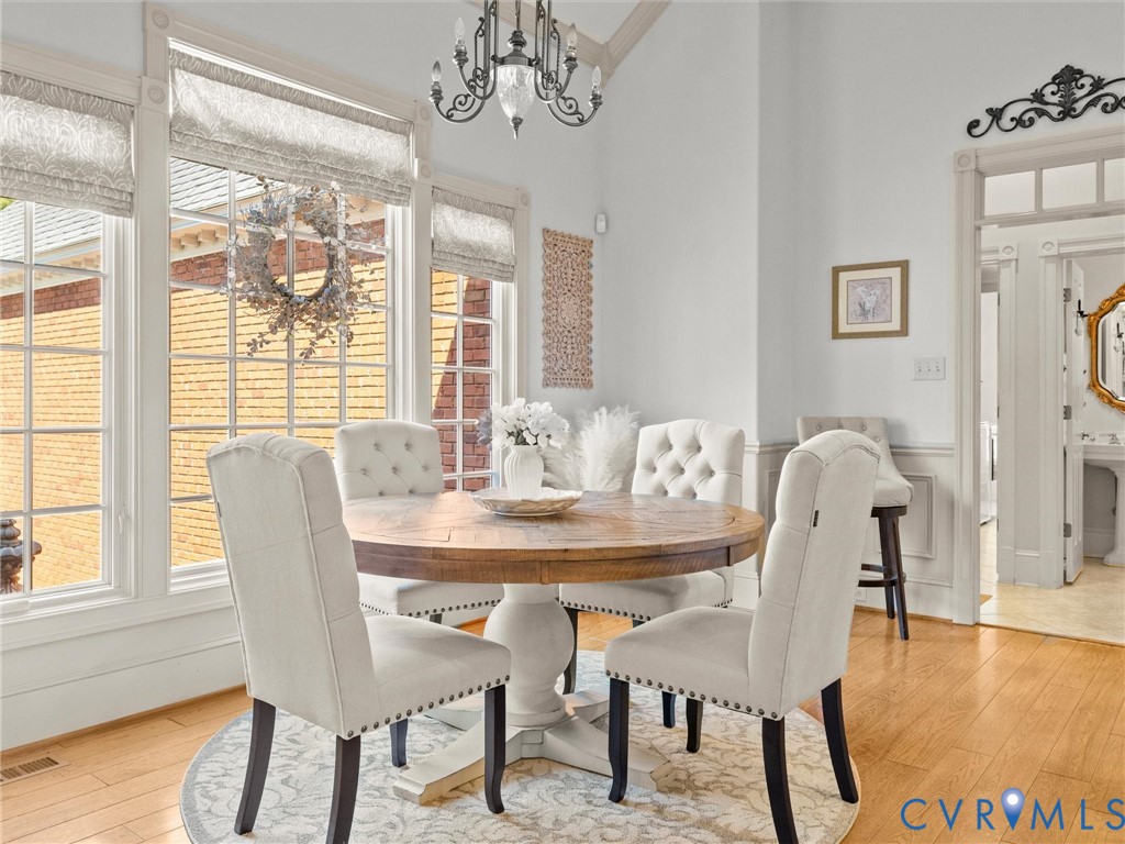 24200 Pear Orchard Road Moseley, VA 23120 - Photo 37 of 66 a dining room with furniture a chandelier and wooden floor