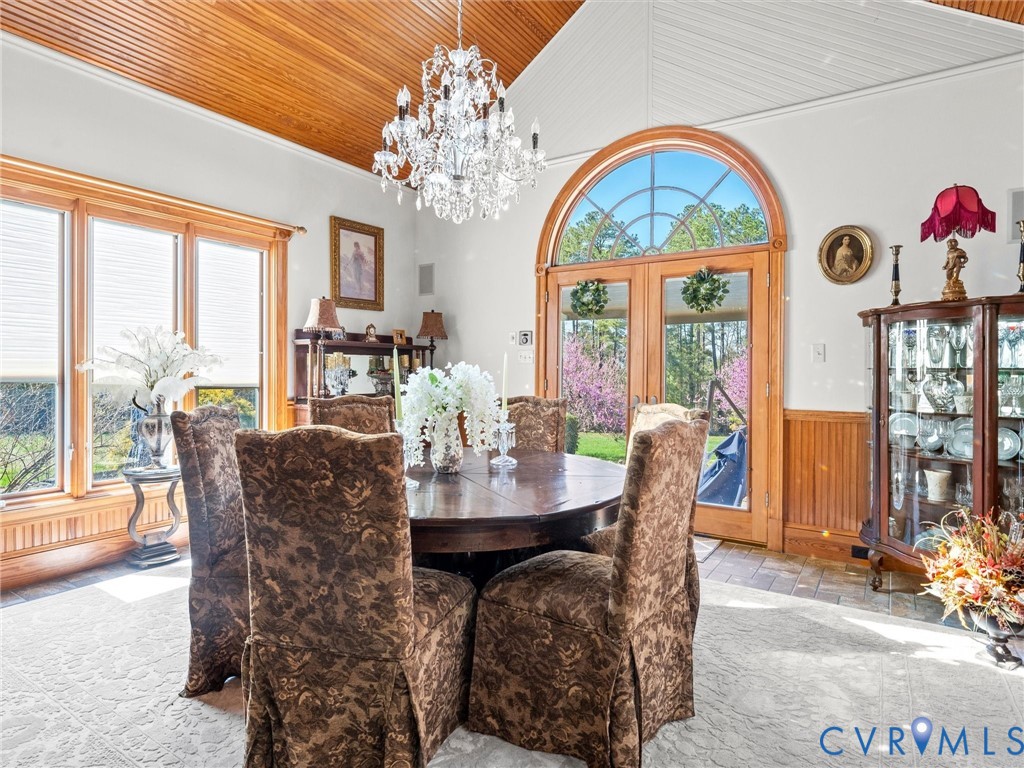 24200 Pear Orchard Road Moseley, VA 23120 - Photo 40 of 66 a view of a dining room with furniture a chandelier and large windows