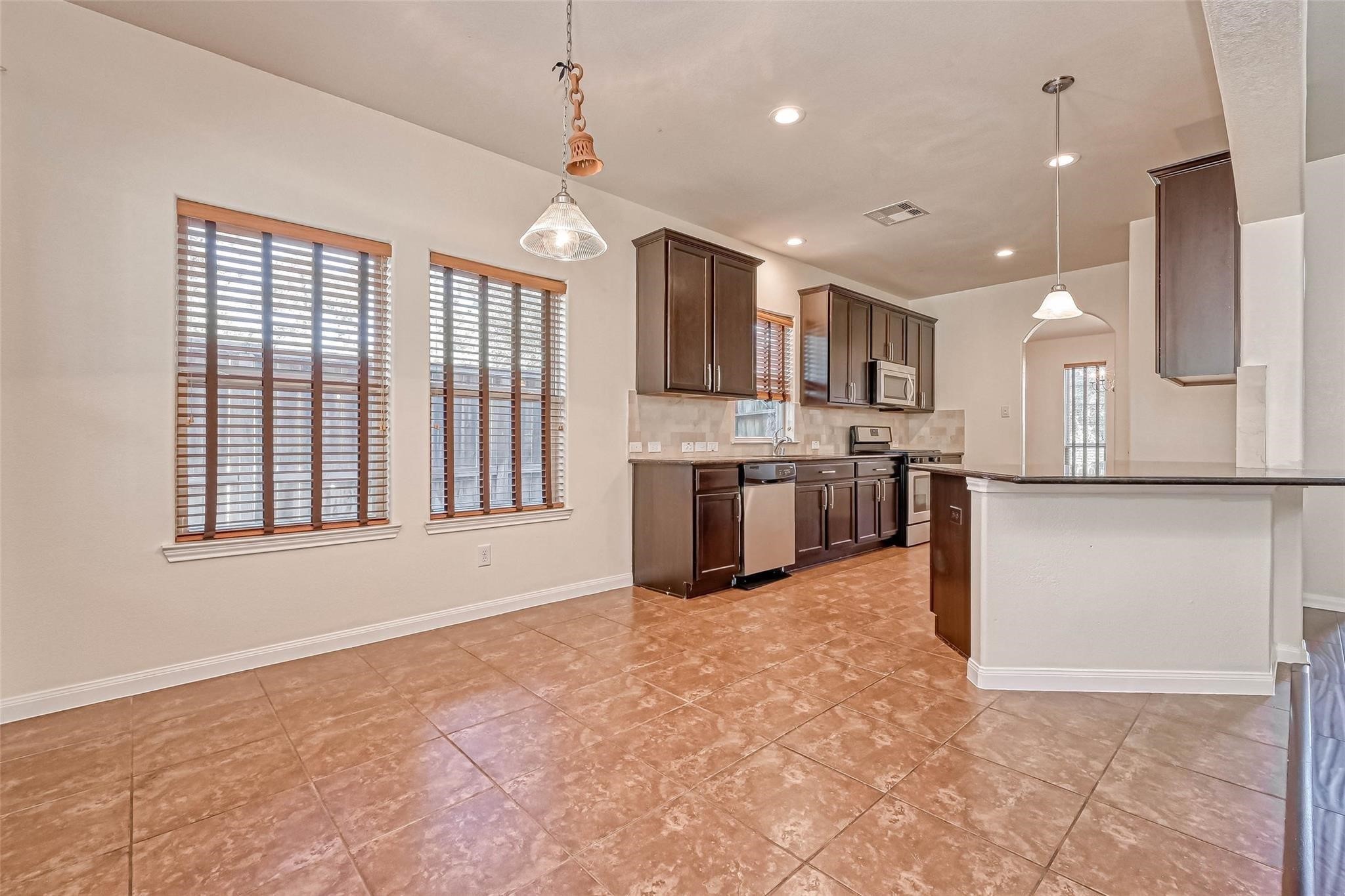 20555 Bonds Creek Lane Spring, TX 77388 - Photo 11 of 36 a large kitchen with kitchen island a stove a sink dishwasher and a refrigerator