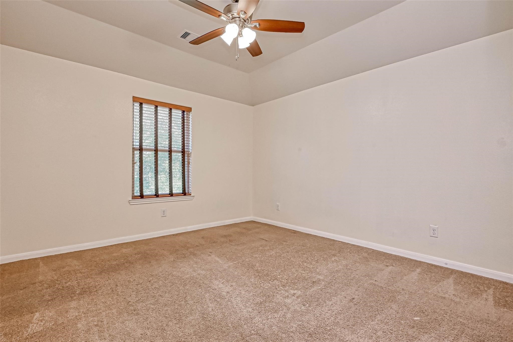 20555 Bonds Creek Lane Spring, TX 77388 - Photo 22 of 36 an empty room with windows and fan