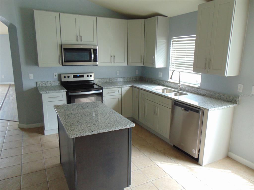 2946 Conner Lane Kissimmee, FL 34741 - Photo 2 of 13 a kitchen with stainless steel appliances granite countertop a sink stove and microwave