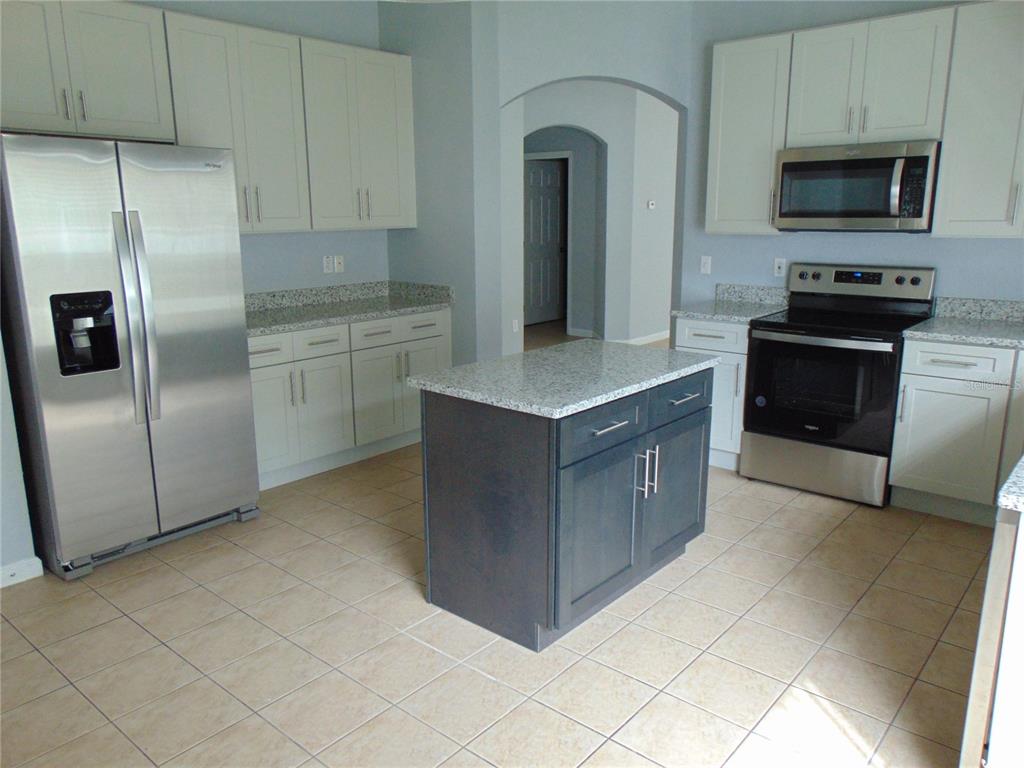 2946 Conner Lane Kissimmee, FL 34741 - Photo 3 of 13 a kitchen with stainless steel appliances granite countertop a refrigerator and a stove top oven