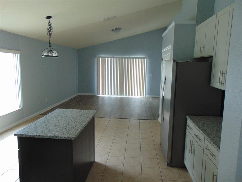 2946 Conner Lane Kissimmee, FL 34741 - Photo 4 of 13 a kitchen with kitchen island a refrigerator stove and sink